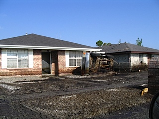 Destroyed front yard and abandoned house